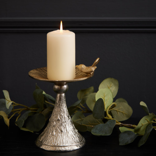 Gold bird candle holder on a black background.
